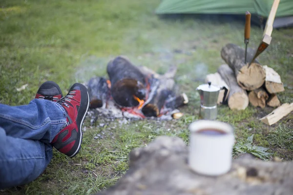 Ateşin yanında kahve içme adam.