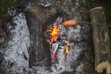 Ateşte sosis pişirme.
