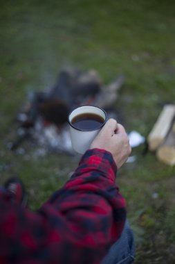 Adam bir çadır kampında yangın kahve hazırlar.