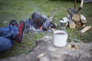 Adam bir çadır kampında yangın kahve hazırlar.