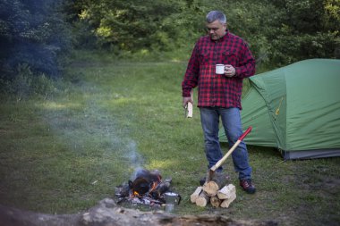 Adam bir çadır kampında yangın kahve hazırlar.