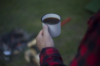 Adam bir çadır kampında yangın kahve hazırlar.