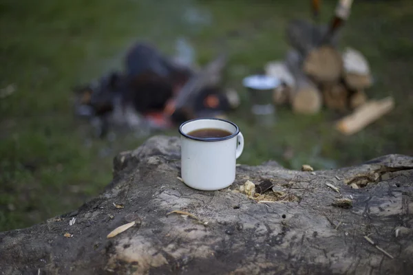 L'uomo prepara il caffè su un fuoco in un campo di tenda . — Foto Stock