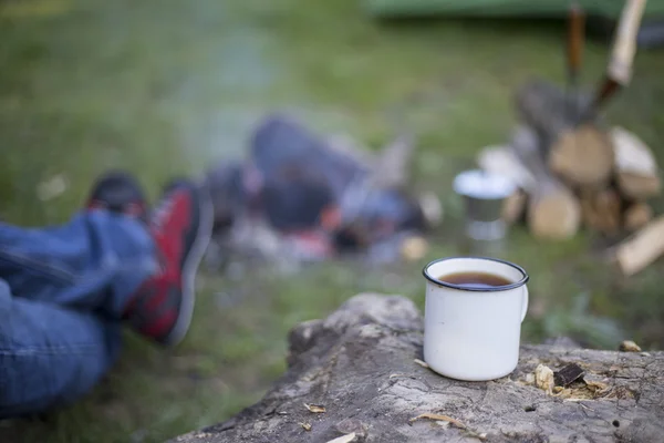 L'uomo prepara il caffè su un fuoco in un campo di tenda . — Foto Stock