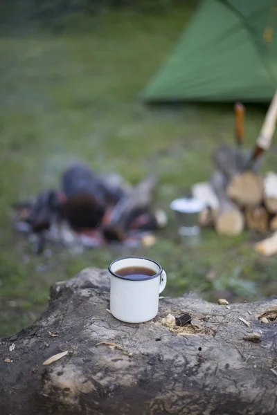 L'uomo prepara il caffè su un fuoco in un campo di tenda . — Foto Stock