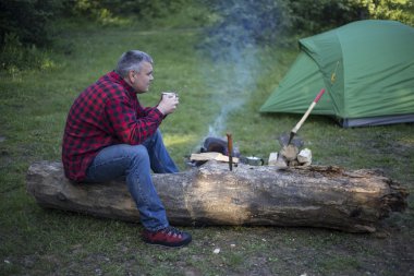 Adam ateş üzerinde kahve pişiriyor.