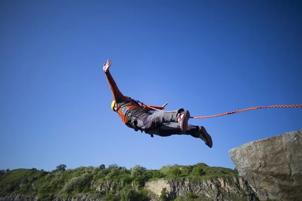 Mit einem Seil von einer Klippe springen. — Stockfoto