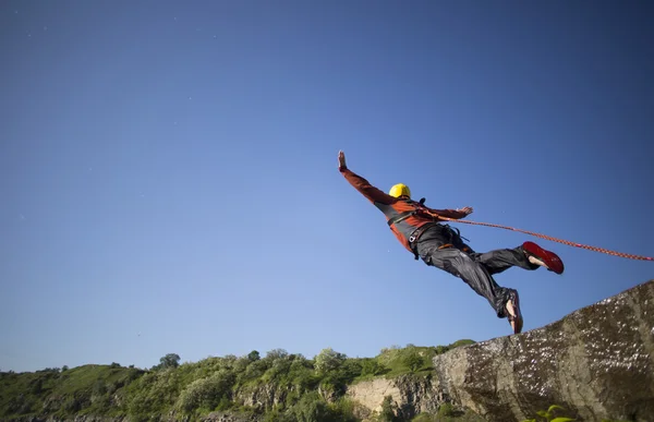 Mit einem Seil von einer Klippe springen. — Stockfoto