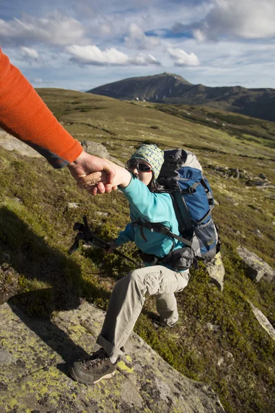 Рука помощи - туристка женщина получает помощь в походе улыбаясь счастливый преодоление препятствия . — стоковое фото