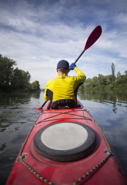 Kırmızı kayık bir adam su bendi kapağı.