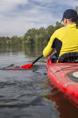 Kırmızı kayık bir adam su bendi kapağı.