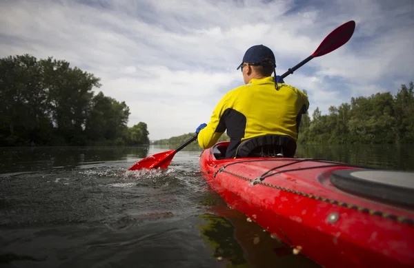 A man paddles a red kayak. — Stock Photo, Image