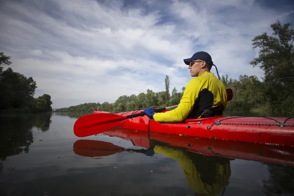 Un homme pagaie un kayak rouge . — Photo