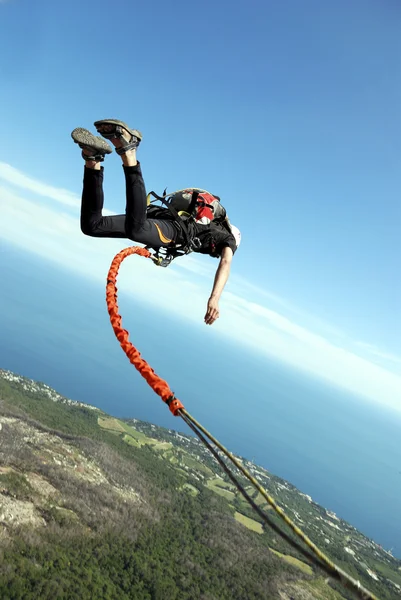 Springen van een rots in een canyon met een touw. — Stockfoto