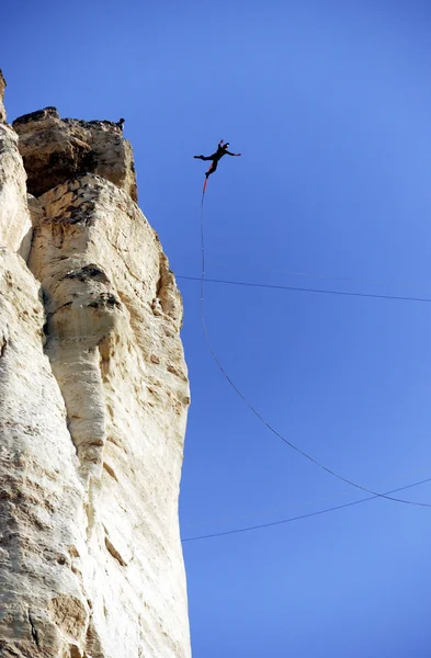 ロープを使って渓谷に崖から飛び降りる. — ストック写真