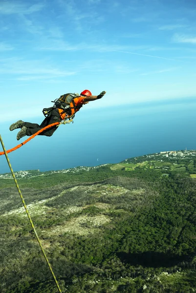 Mit einem Seil von einer Klippe in eine Schlucht springen. — Stockfoto