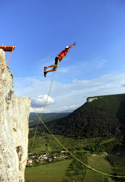 Jump off a cliff into a canyon with a rope. — Stock Photo, Image