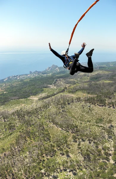 Jump off a cliff into a canyon with a rope. — Stock Photo, Image