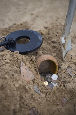 Pot altın sikkelerin metal detektörü, yeşil çim arka plan yardımıyla toplanan.