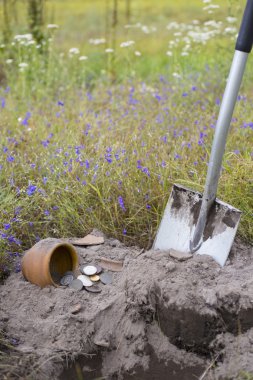 Pot altın sikkelerin metal detektörü, yeşil çim arka plan yardımıyla toplanan.