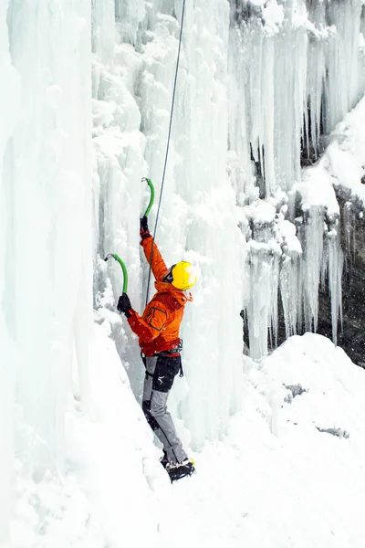 Homem escalando cascata congelada . — Fotografia de Stock