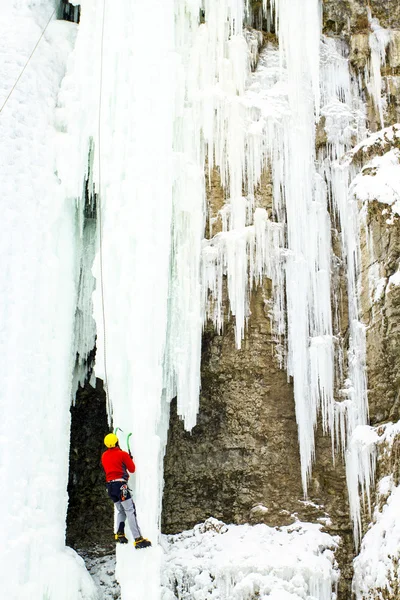 Man climbing frozen waterfall. — Stock Photo, Image