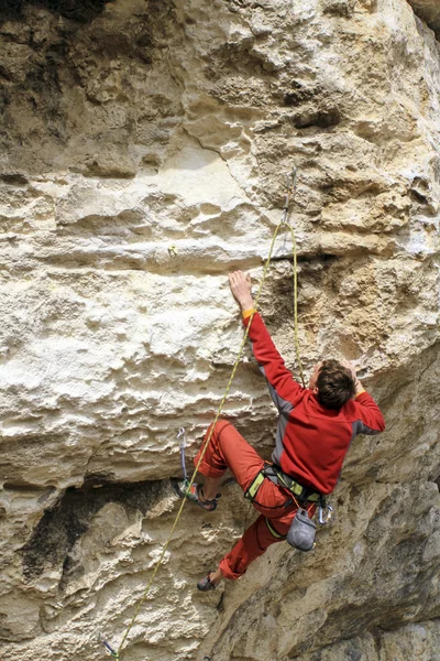 Cliffhanger.Jovem alpinista pendurado por um penhasco . — Fotografia de Stock