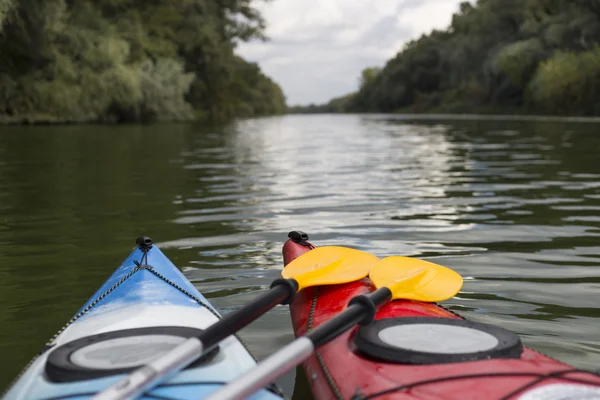 Kajakozás a riveren. Fiatal férfi kemény, sok-sok a fröccsenő a kajak evezni. — Stock Fotó