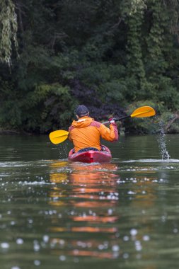 Nehir kayağı. Genç adam sert su sıçramalarına sürü kayık kürek çekmeye.