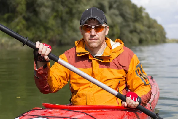 Kayak sur la rivière.Jeune homme pagayant dur le kayak avec beaucoup d'éclaboussures . — Photo