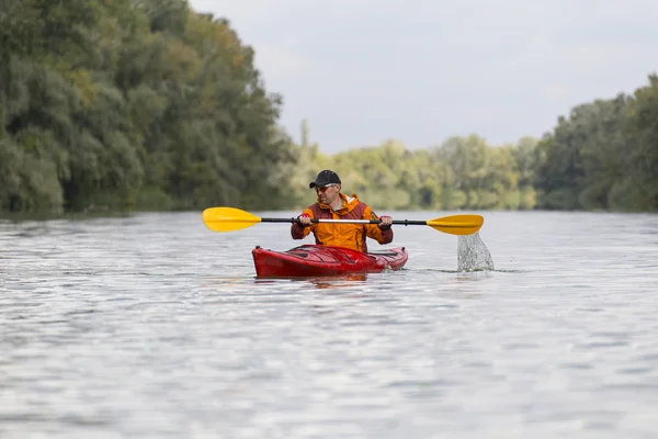 Kayak en el río.Joven remando duro el kayak con un montón de salpicaduras . — Foto de Stock