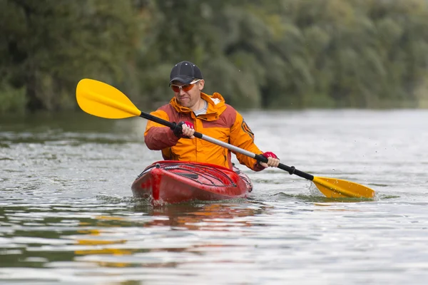 Kayak sur la rivière.Jeune homme pagayant dur le kayak avec beaucoup d'éclaboussures . — Photo