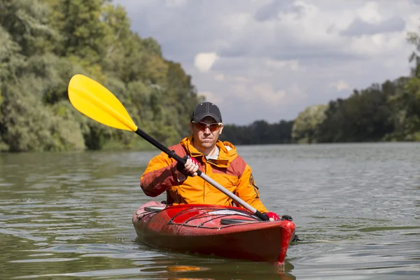 Kayak en el río.Joven remando duro el kayak con un montón de salpicaduras . —  Fotos de Stock