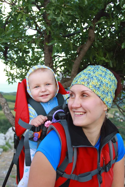 Een jonge vrouw trekking met haar baby — Stockfoto