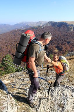 Dağ taş cliff tırmanmaya arkadaşına yardım elini veren adam