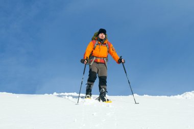 Dağlarda kar ayakkabıları bir sırt çantası ve çadır hiking kış.