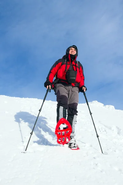 Senderismo de invierno en las montañas en raquetas de nieve con una mochila y tienda de campaña . — Foto de Stock