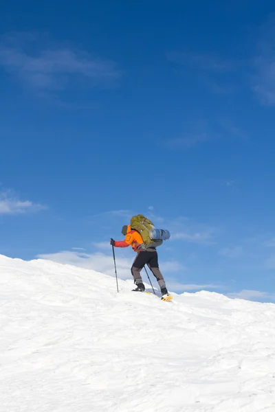 Senderismo de invierno en las montañas en raquetas de nieve con una mochila y tienda de campaña . —  Fotos de Stock