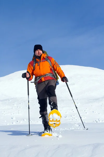 Dağlarda kar ayakkabıları bir sırt çantası ve çadır hiking kış. — Stok fotoğraf