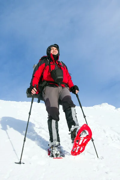 Senderismo de invierno en las montañas en raquetas de nieve con una mochila y tienda de campaña . — Foto de Stock