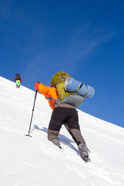 Winter wandelen in de bergen op sneeuwschoenen met een rugzak en tent. — Stockfoto