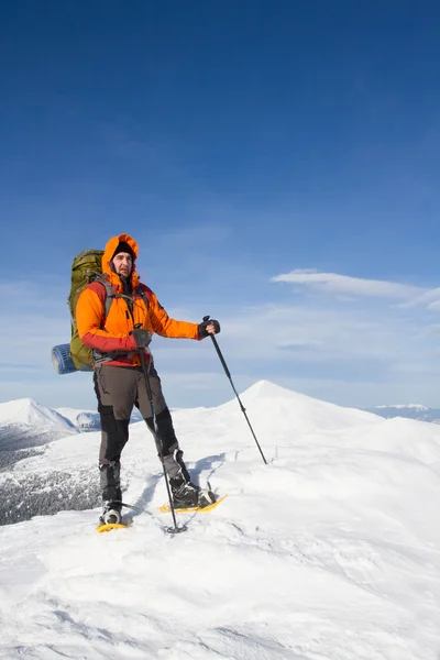 Winter hiking in the mountains on snowshoes with a backpack and tent. — Stock Photo, Image