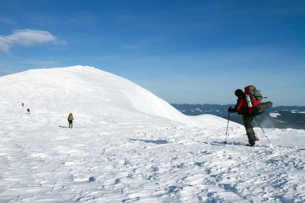 Senderismo de invierno en las montañas en raquetas de nieve con una mochila y tienda de campaña . — Foto de Stock