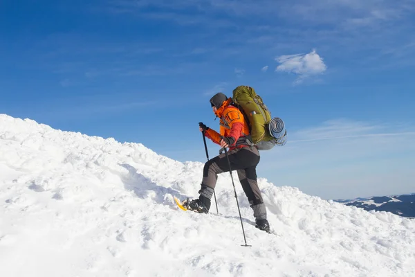 Winter hiking in the mountains on snowshoes with a backpack and tent. — Stock Photo, Image