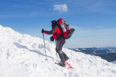 Dağlarda kar ayakkabıları bir sırt çantası ve çadır hiking kış.
