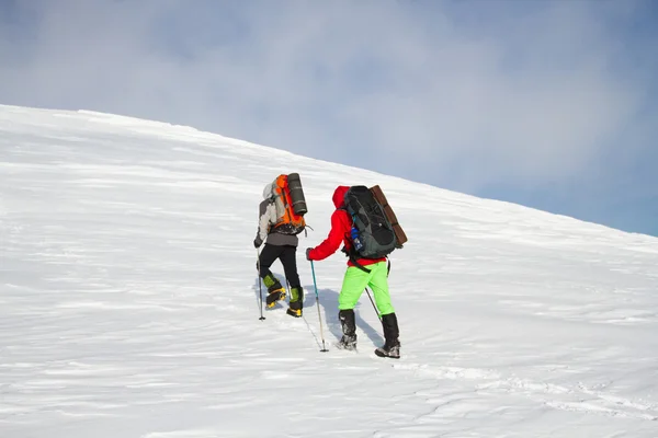 在山里徒步旅行带着背包和帐篷雪的冬天. — 图库照片