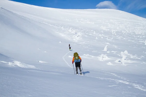 在山里徒步旅行带着背包和帐篷雪的冬天. — 图库照片