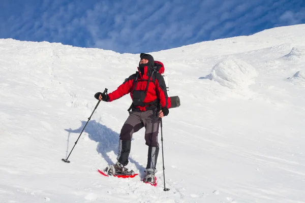 Winter hiking in the mountains on snowshoes with a backpack and tent. — Stock Photo, Image