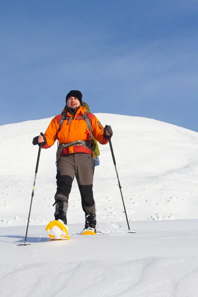 Dağlarda kar ayakkabıları bir sırt çantası ve çadır hiking kış. — Stok fotoğraf