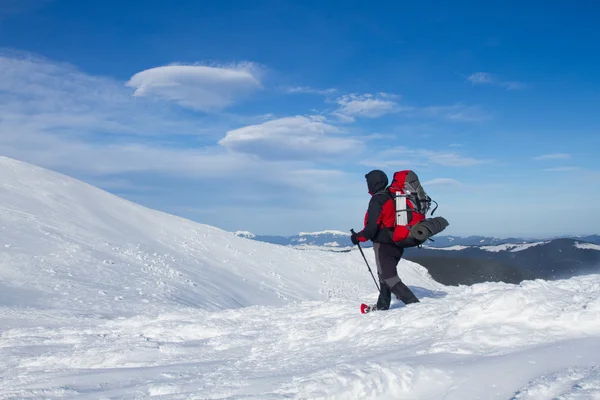 Caminhadas de inverno nas montanhas em sapatos de neve com uma mochila e tenda . — Fotografia de Stock